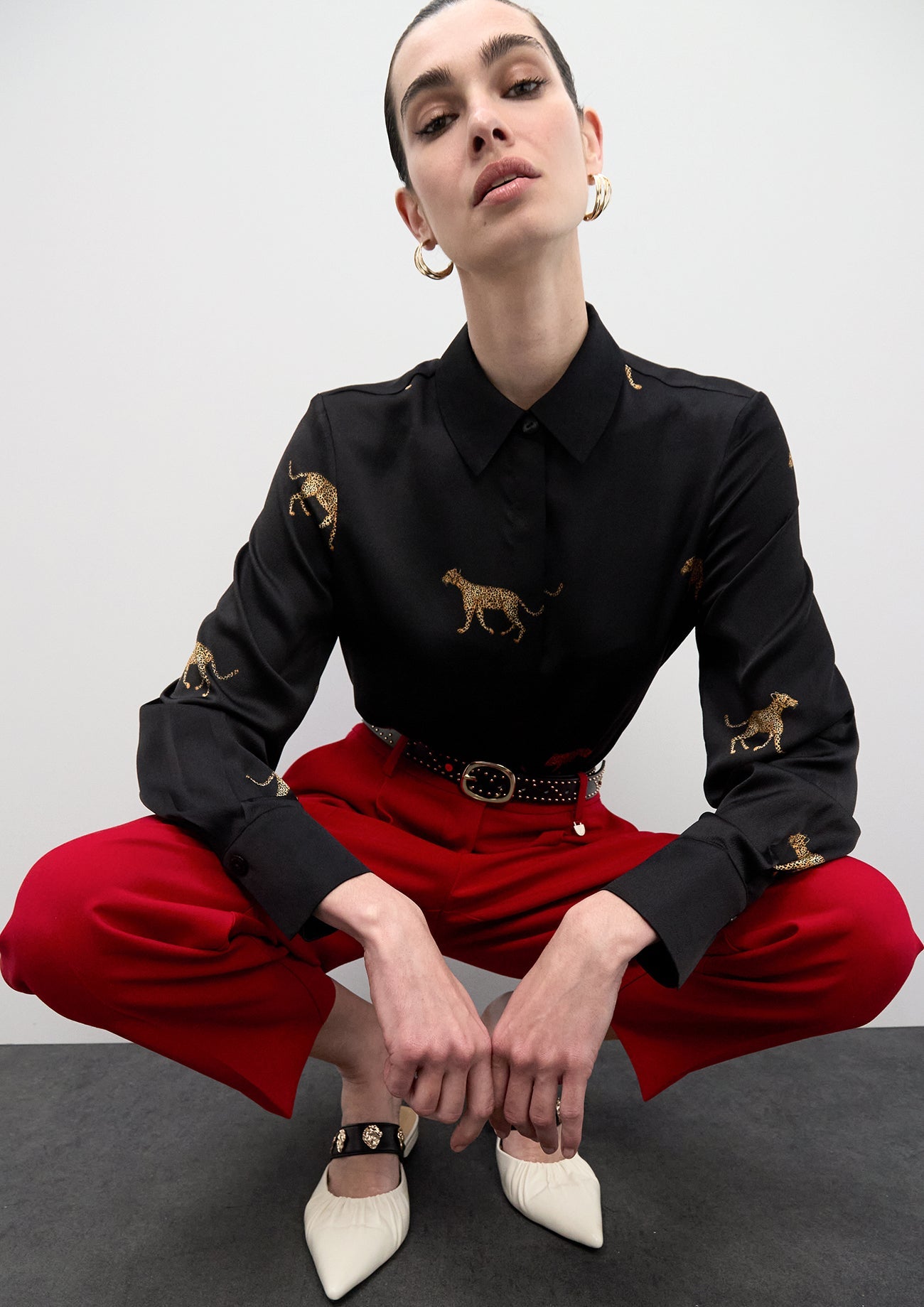 Belt with logo-embossed studs and metallic applications