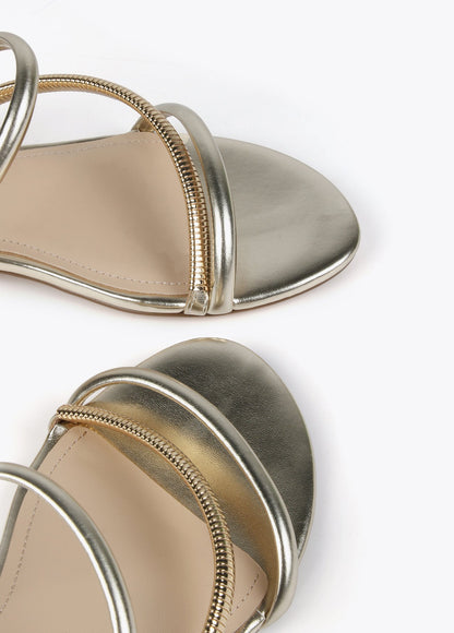 Flat sandals with metallic straps and gold heel